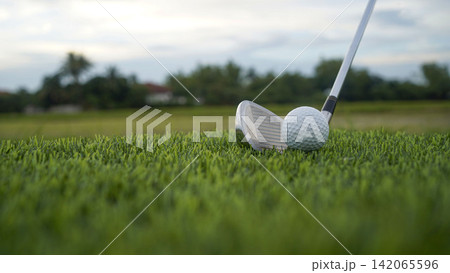 Golf clubs and balls on a green lawn in a beautiful golf course with morning sunshine. 142065596