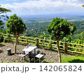 chairs and tables in an open space on a hill. 142065824