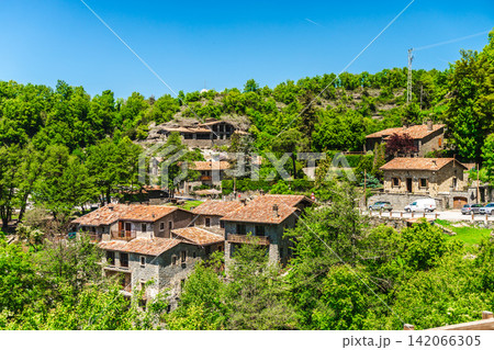 Panoramic view of traditional stone houses surrounded by lush green forest in Rupit village, Catalonia, Spain Panoramic view of traditional stone houses surrounded by lush green forest in Rupit village, Catalonia, Spain 142066305