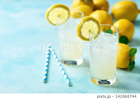 A glass of cold lemonade with fresh lemon slice  on the kitchen table. 142068744