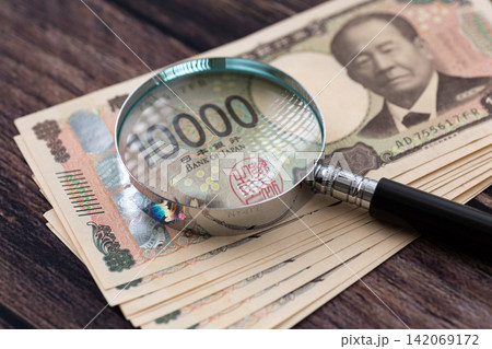 10万円分の一万円紙幣と虫眼鏡 10万円分の一万円紙幣と虫眼鏡 142069172
