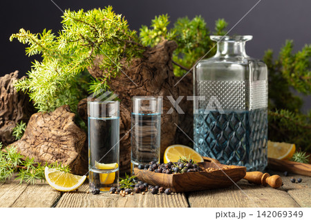 Gin with ingredients on an old wooden table. Gin with ingredients on an old wooden table. 142069349