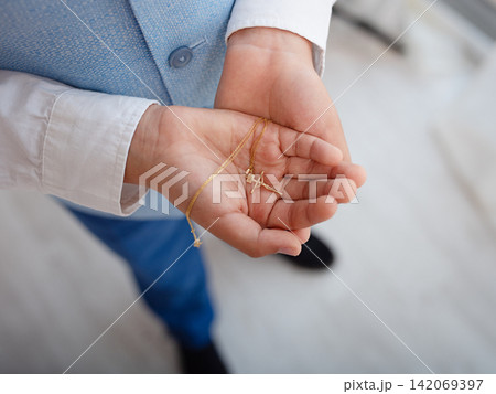 A Catholic cross is in children's hands. A Catholic cross is in children's hands. 142069397