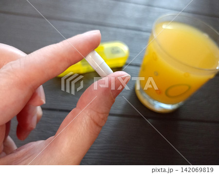 A woman holds an iron capsule between her fingers A woman holds an iron capsule between her fingers 142069819
