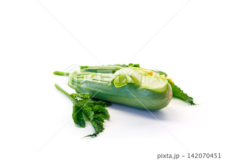 Fresh zucchini with peeled ribbons and leaves isolated on white background 142070451