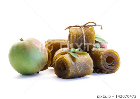 Homemade apple fruit leather rolls with fresh apple isolated on white background Homemade apple fruit leather rolls with fresh apple isolated on white background 142070472