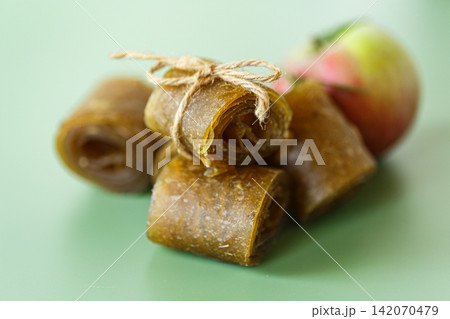 Healthy natural apple snack rolls arranged with fresh fruit on green background Healthy natural apple snack rolls arranged with fresh fruit on green background 142070479