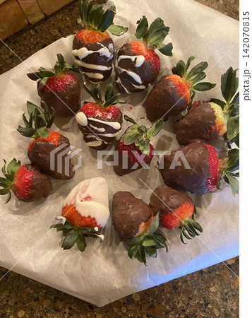 Fresh strawberries paired with rich chocolate bars create a vibrant and tempting contrast. Bright red fruit and smooth cocoa make a naturally irresistible duo. 142070815
