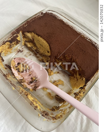 Soft and creamy tiramisu slice layered with rich mascarpone, espresso-soaked ladyfingers, and a dusting of cocoa powder, offering a perfect balance of sweetness and bold coffee flavor in every bite. 142070832