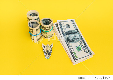 Money airplane with hundred dollar bills on yellow background Money airplane with hundred dollar bills on yellow background 142071507