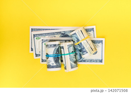 Stack and rolls of hundred dollar bills Stack and rolls of hundred dollar bills 142071508