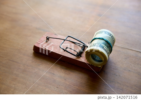 Hundred dollar bills caught in wooden mousetrap Hundred dollar bills caught in wooden mousetrap 142071516