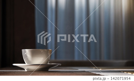 a morning hot coffee in white cup in sunshine scene with shade and white smoke from hot water 142071954