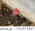 コンクリート際に設置された赤いプラスチック製境界杭 142073837
