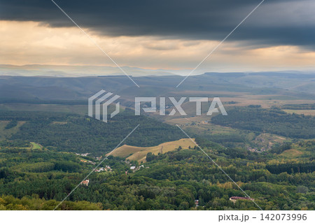 Layers of green mountains and hills in the haze during sunset. Panoramic View of Green hills and Meadow. Layers of green mountains and hills in the haze during sunset. Panoramic View of Green hills and Meadow. 142073996
