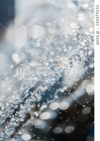 Splashes and jets of water against light background. 142074231