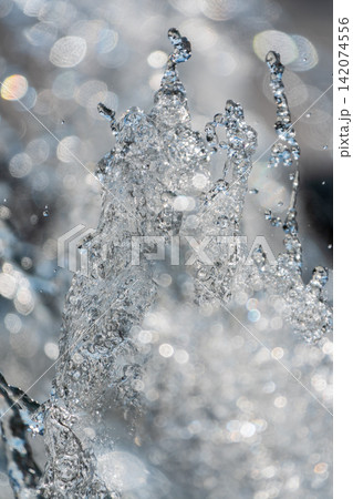 Splashes and jets of water against light background. 142074556