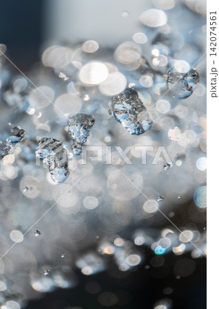 Splashes and jets of water against light background. Splashes and jets of water against light background. 142074561