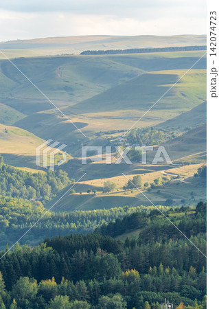 Layers of green mountains and hills in the haze during sunset. Panoramic View of Green hills and Meadow. Layers of green mountains and hills in the haze during sunset. Panoramic View of Green hills and Meadow. 142074723