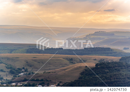 Layers of green mountains and hills in the haze during sunset. Panoramic View of Green hills and Meadow. Layers of green mountains and hills in the haze during sunset. Panoramic View of Green hills and Meadow. 142074730