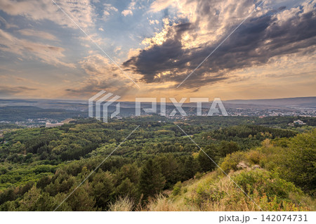 View of the mountains and Kislovodsk from the observation decks of the Kislovodsk Park. Evening sunset over the mountains of Kislovodsk. 142074731