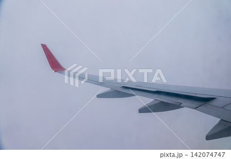 View from the airplane window at a beautiful cloudy sky and the airplane wing 142074747