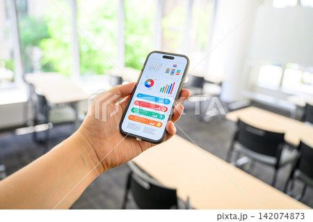 スマホ画面のグラフを指差す手、ビジネスアプリ スマホ画面のグラフを指差す手、ビジネスアプリ 142074873