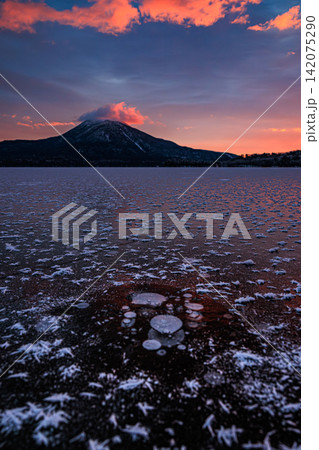 朝焼けに染まる空と阿寒湖の結氷した氷上に広がるフロストフラワーおよび雄阿寒岳の絶景 142075290