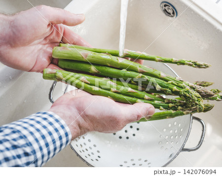 Male hands wash asparagus Male hands wash asparagus 142076094