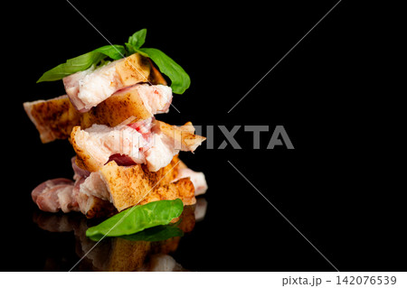 Natural seasoned pork fat with green basil on elegant black surface Natural seasoned pork fat with green basil on elegant black surface 142076539