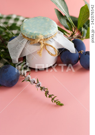 Sweet plum jam in decorated jar on pink background 142076542