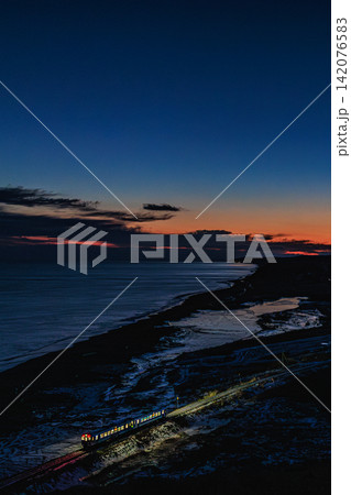 夕闇迫る尺別の丘から望む茜色の空と暗闇を照らし走り抜ける根室本線の列車 夕闇迫る尺別の丘から望む茜色の空と暗闇を照らし走り抜ける根室本線の列車 142076583
