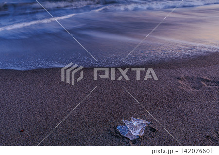 静かな波が打ち寄せる冬の砂浜で澄んだ光を放つ宝石のようなジュエリーアイスの風景 静かな波が打ち寄せる冬の砂浜で澄んだ光を放つ宝石のようなジュエリーアイスの風景 142076601