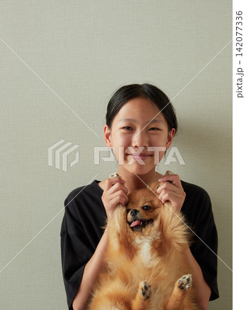 夏の家のリビングで可愛いポメラニアンの子犬と遊んでいる夏休み中の女子中学生の姿 夏の家のリビングで可愛いポメラニアンの子犬と遊んでいる夏休み中の女子中学生の姿 142077336