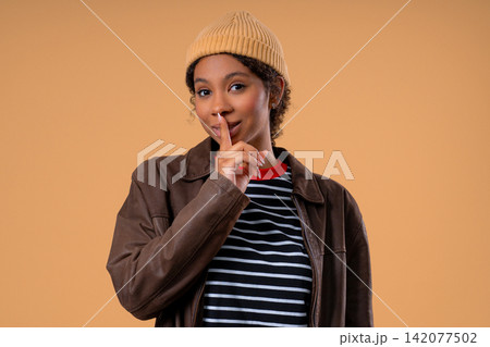 Young female teenage girl brings finger to lips with calm face, asking for quiet. Secrecy, gossip Young female teenage girl brings finger to lips with calm face, asking for quiet. Secrecy, gossip 142077502