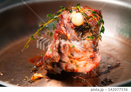 Beef roast with herbs and garlic in a frying pan, close-up view Beef roast with herbs and garlic in a frying pan, close-up view 142077556