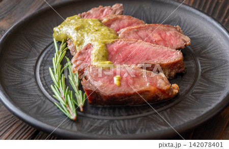 Sliced Wagyu beef steak medium rare with herb sauce rosemary gourmet presentation Sliced Wagyu beef steak medium rare with herb sauce rosemary gourmet presentation 142078401