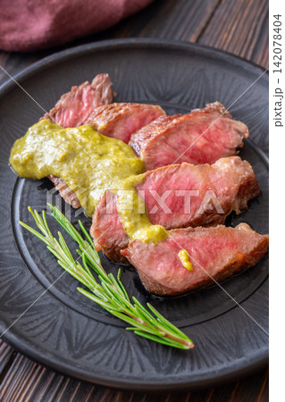 Sliced Wagyu beef steak medium rare with herb sauce rosemary gourmet presentation Sliced Wagyu beef steak medium rare with herb sauce rosemary gourmet presentation 142078404