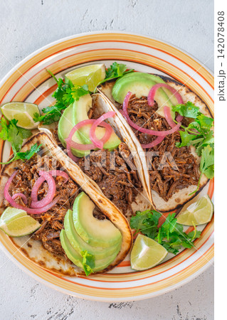 Pulled beef tacos with avocado pickled onions cilantro lime Mexican street food Pulled beef tacos with avocado pickled onions cilantro lime Mexican street food 142078408