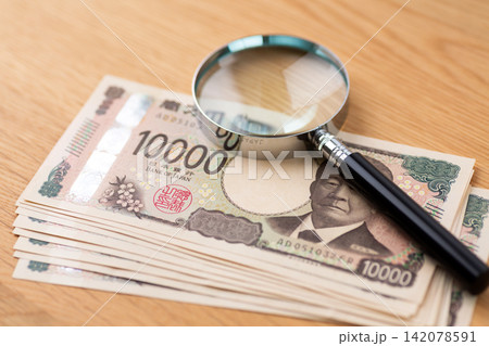 10万円分の一万円紙幣と虫眼鏡 10万円分の一万円紙幣と虫眼鏡 142078591