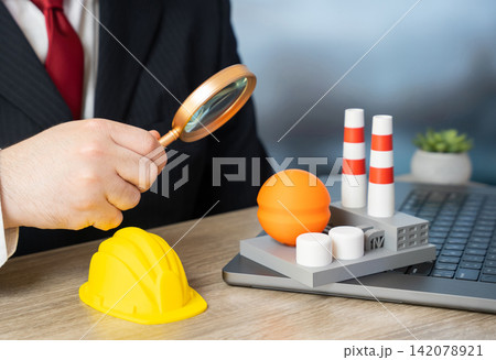 A businessman is evaluating an industrial plant construction project. Chemical production, oil refinery, gas infrastructure, power plant. Investments in modernization. 142078921