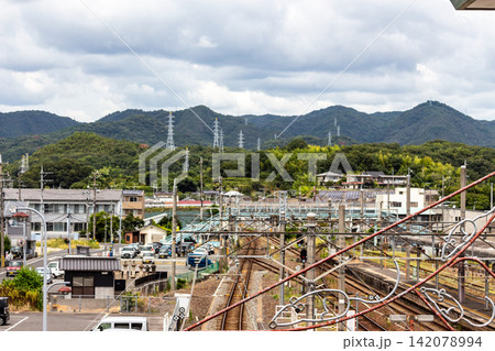 山並みと鉄塔を望む郊外の駅と鉄道インフラの風景(俯瞰) 山並みと鉄塔を望む郊外の駅と鉄道インフラの風景(俯瞰) 142078994