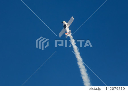 Stunt aerobatic plane performing stunts in air Stunt aerobatic plane performing stunts in air 142079210