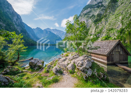Obersee mountain lake boat shed in Bavaria Germany with rocky shoreline. Obersee mountain lake boat shed in Bavaria Germany with rocky shoreline. 142079283