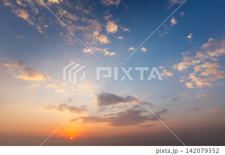 Dramatic sunset sky showcasing vibrant colors and soft clouds Dramatic sunset sky showcasing vibrant colors and soft clouds 142079352