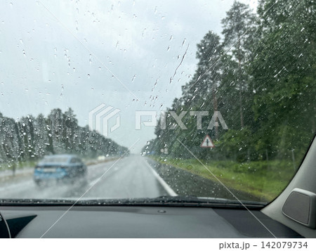 Rainy highway view through car windshield while driving 142079734