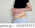 Pregnant woman showing love and connection with her unborn baby by making a heart shape with her hands on her belly. Maternity support belt, prenatal care, pregnancy health and motherhood concept. 142079753