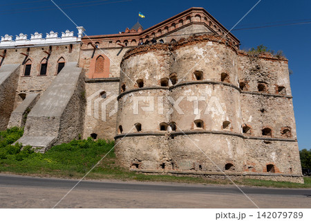 Historic Medzhybizh fortress stone bastion and decorative white battlements with Ukrainian flag Historic Medzhybizh fortress stone bastion and decorative white battlements with Ukrainian flag 142079789