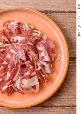 Slices of pork pancetta, ham, or bacon for a festive antipasto platter 142080106