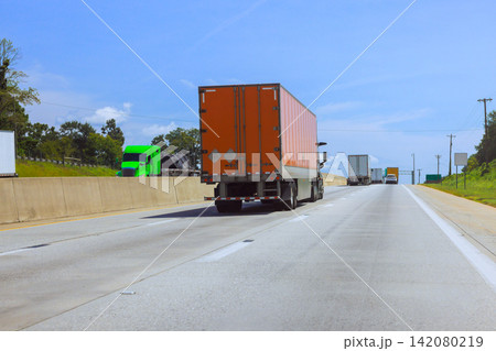 Trucks move along American interstate highway surrounded by green fields. Trucks move along American interstate highway surrounded by green fields. 142080219